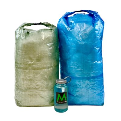 A small green and large blue DCF pack Liner next to a water bottle