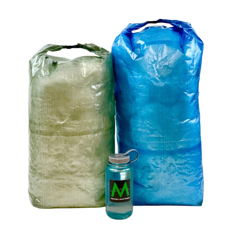 A small green and large blue DCF pack Liner next to a water bottle