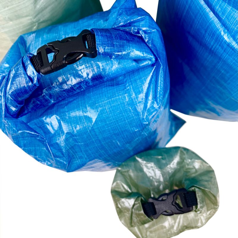 Top down view of DCF Dry Bags showing the roll top of a blue and green bag