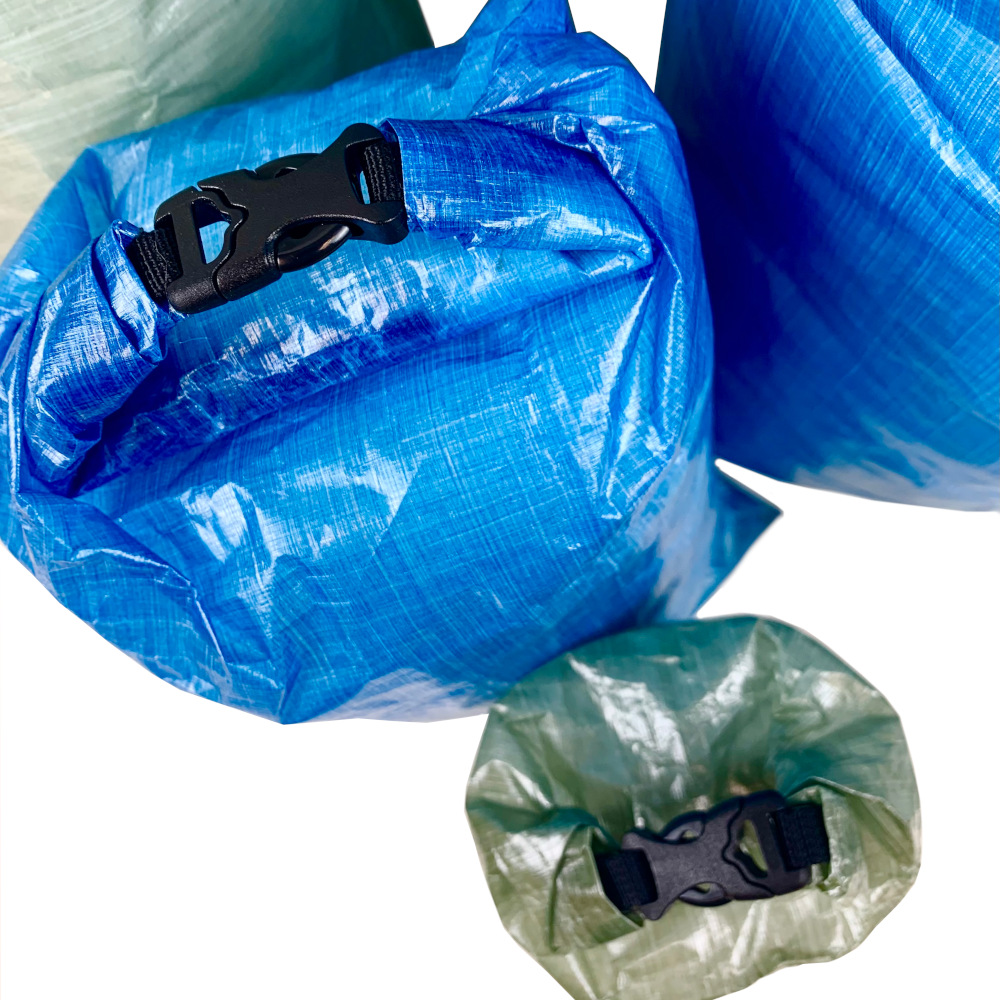 Top down view of DCF Dry Bags showing the roll top of a blue and green bag