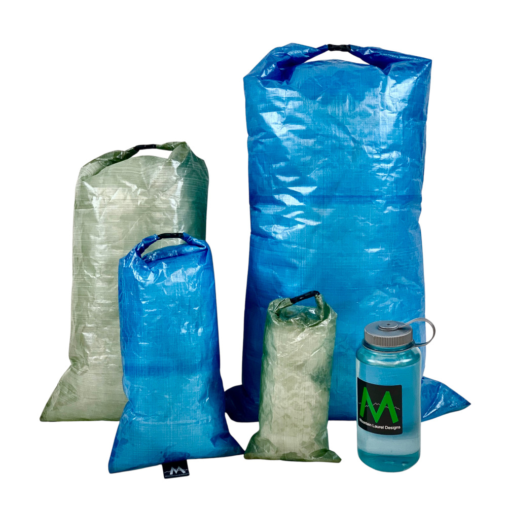 An XLarge, Large, Medium, and Small Dry bag next to a water bottle