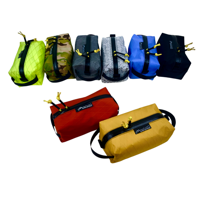 MLD Dopp Kit Bags in all 8 Available Colors. Back Row: Hi-Viz Yellow, Camo, Medium Gray, Light Gray, Bluebell, Black. Front Row: Chili Red and Marigold
