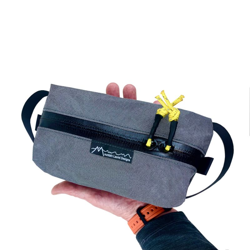 MLD Dopp Kit Bag in Medium Grey. Shown in hand to display size.