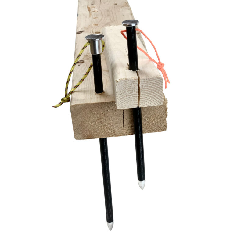 Two Carbon Fiber Nano Stakes nailed through 2 x 4 wood boreds